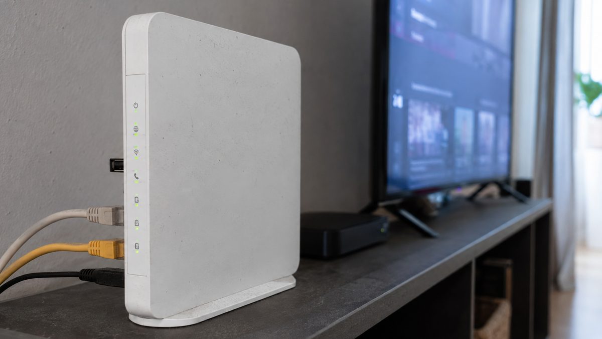 Home router beside a television, illustrating IPTV speed requirements